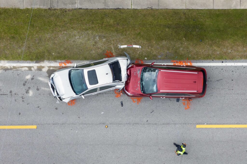 Aerial view of a red car rear-ending a white car